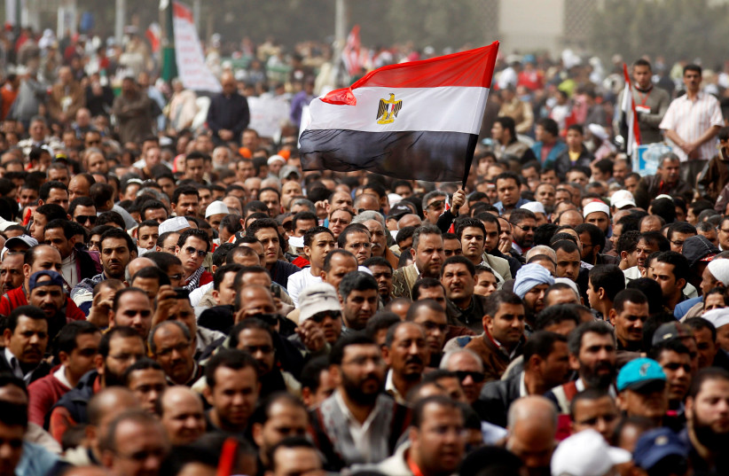 A man holds an Egyptian flag during a rally at Tahrir Square, in Cairo February 25, 2011 (photo credit: REUTERS/PETER ANDREWS)