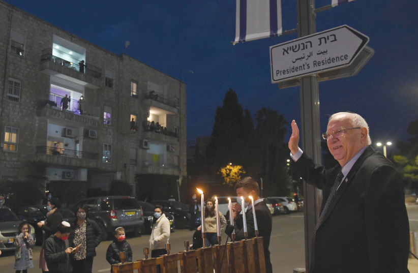 RIVLIN WAVES TO his neighbors on the fourth night of Hanukkah.  (photo credit: MARK NEYMAN/GPO)