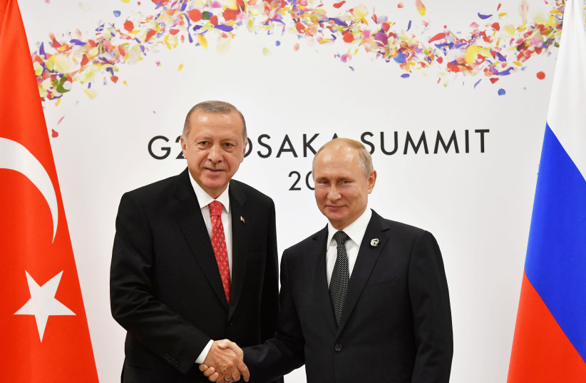 Russian President Vladimir Putin (R) shakes hands with Turkish President Recep Tayyip Erdogan during their bilateral meeting on the sidelines of the G20 leaders summit in Osaka, Japan, on June 29, 2019.  (photo credit: YURI KADOBNOV/POOL/FILE PHOTO)