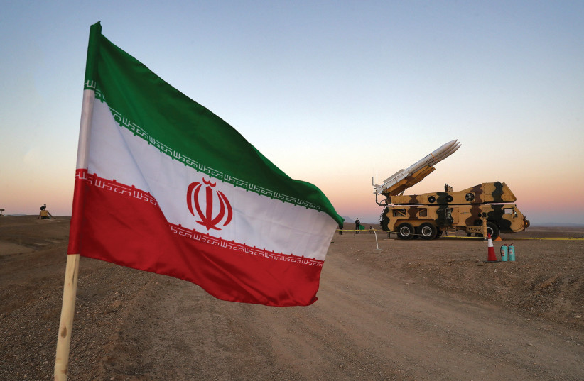 UMA BANDEIRA IRANIANA é fotografada perto de um míssil durante um exercício militar, com a participação das unidades de defesa aérea do Irã em outubro.  (West Asia News Agency / Reuters) (crédito da foto: WEST ASIA NEWS AGENCY / REUTERS)