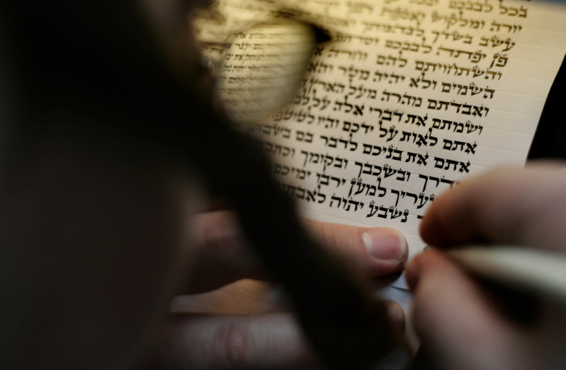 A sofer writes verses from the Shema prayer on a 'klaf' with a quill pen (photo credit: OLIVIER FITOUSSI/FLASH90)
