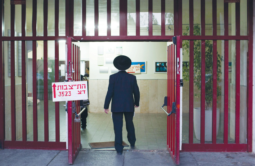 A YOUNG MAN enters an army recruiting center in Jerusalem. (photo credit: YONATAN SINDEL/FLASH 90)