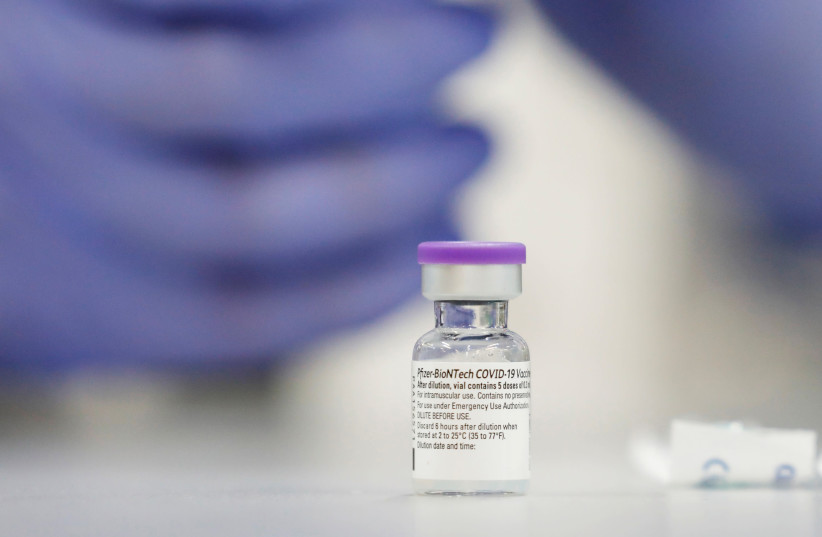 A vial of the Pfizer vaccine against the coronavirus disease (COVID-19) is seen as medical staff are vaccinated at Sheba Medical Center in Ramat Gan, Israel (photo credit: REUTERS/AMIR COHEN/FILE PHOTO)