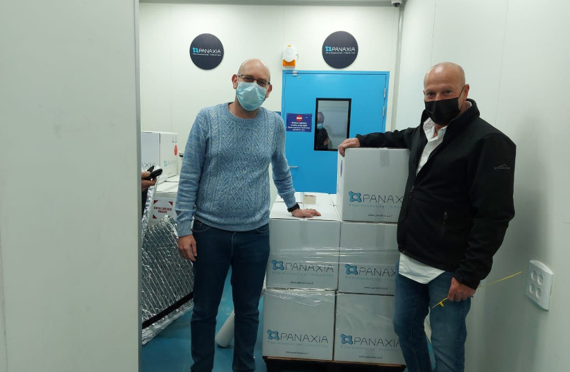 Assi Rotbart, Chief Business Officer and Director at Panaxia, stands with Yuval Landschaft, the director of the Healthy Ministry's Medical Cannabis Unit alongside Israel's first commercial export of medical cannabis products to Germany. (photo credit: PANAXIA)