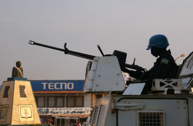 A peacekeeper from the United Nations Multidimensional Integrated Stabilization Mission in the Central African Republic (MINUSCA) armoured personnel carrier (APC) keeps guard as they patrol the streets ahead of the upcoming elections in Bangui, Central African Republic December 26, 2020.  (photo credit: REUTERS/ANTONIE ROLLAND)