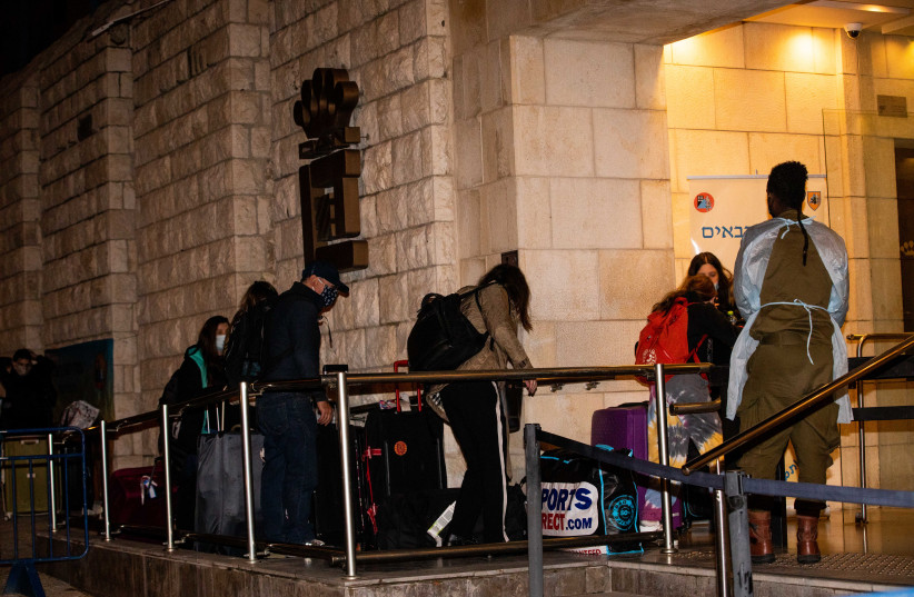 People who arrived on a flight from England arrive to the Dan Panorama Hotel used as a quarantine facility, on December 20, 2020.  (photo credit: YONATAN SINDEL/FLASH 90)