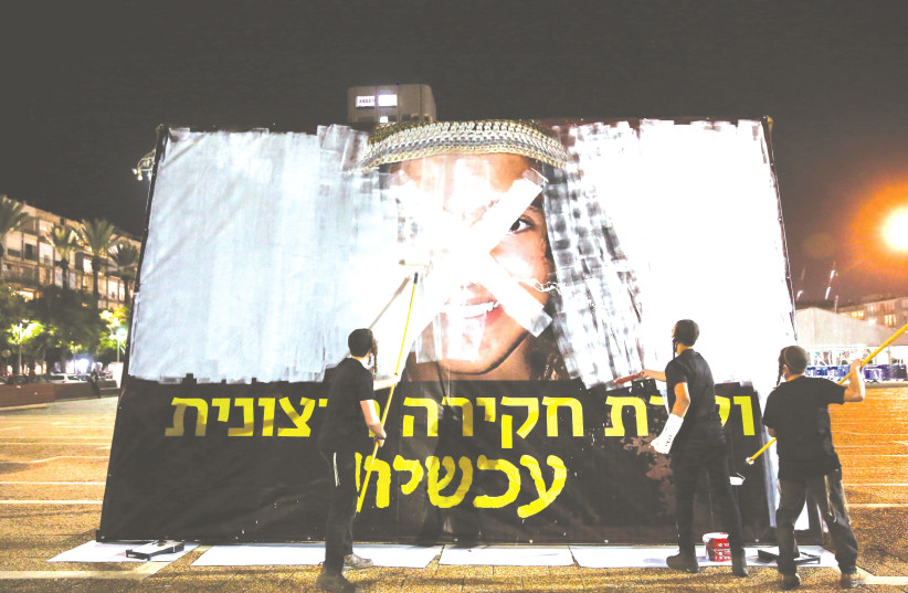 DEMONSTRATORS PAINT over a picture of Ahuvia Sandak in protest against his death, at Rabin Square in Tel Aviv on Tuesday. (photo credit: MIRIAM ALSTER/FLASH90)