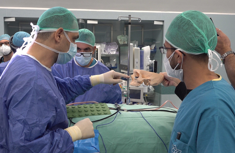 Surgeons are seen examining a model skull ahead of eye surgery using AR technology. (photo credit: ROEE BELCHENS/DENTAL PRO VIDEO)