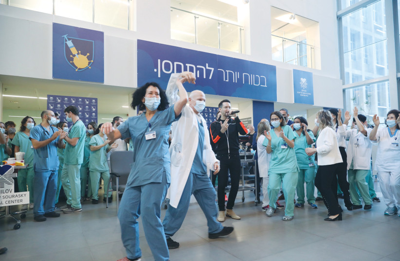 STAFF AT Tel Aviv Sourasky Medical Center (Ichilov) sing and dance along with performer Ivri Lider to celebrate the start of the mass vaccination program. (photo credit: MARC ISRAEL SELLEM/THE JERUSALEM POST)