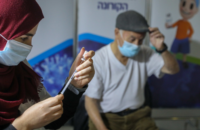 People get vaccinated at the Clalit vaccination center in Jerusalem, January 3, 2020. (photo credit: MARC ISRAEL SELLEM/THE JERUSALEM POST)