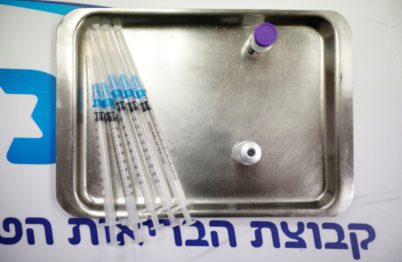 Vials of vaccinations against the coronavirus disease (COVID-19) and syringes are seen as Israel continues its national vaccination drive, during a third national COVID lockdown, at a Maccabi Health Fund branch in Ashdod, Israel December 29, 2020 (photo credit: REUTERS/AMIR COHEN/FILE PHOTO)