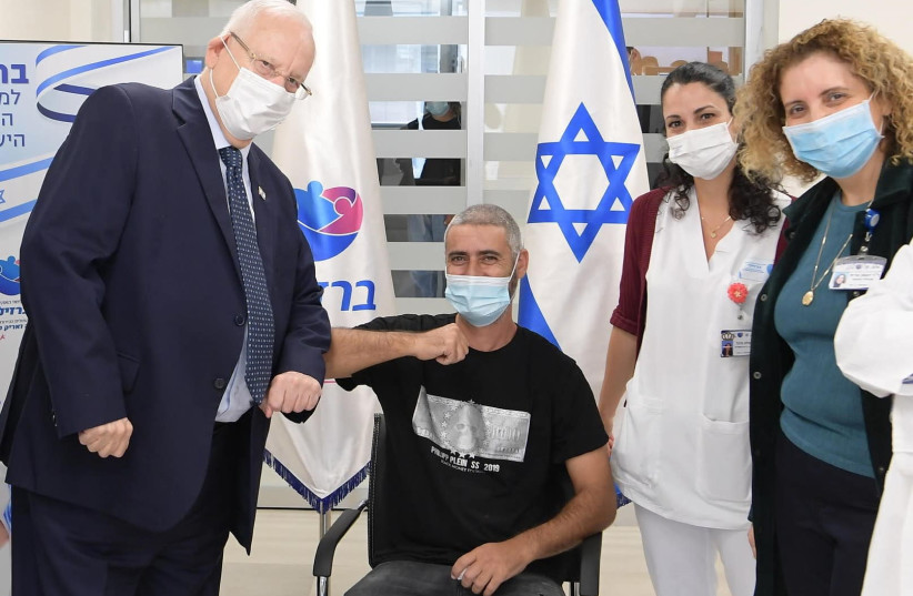 President Reuven Rivlin is seen alongside the first person to receive a dose of the Israel-made coronavirus vaccine as part of the Phase II trials at Ashkelon's Barzilai Medical Center. (photo credit: AMOS BEN-GERSHOM/GPO)