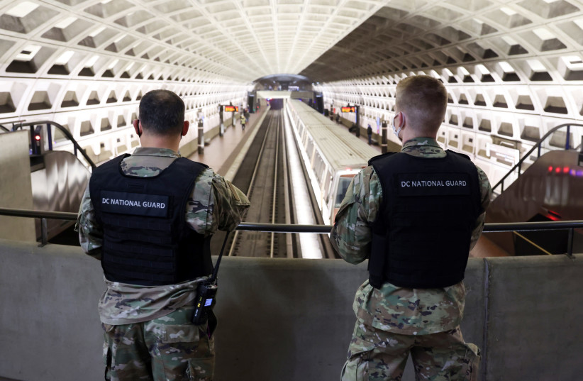 National Guard soldiers keep watch in a nearly empty Metro subway station as Pro-Trump demonstrators rally to protest the results of the 2020 US presidential election during in Washington, US January 5, 2021. (photo credit: JONATHAN ERNST / REUTERS)