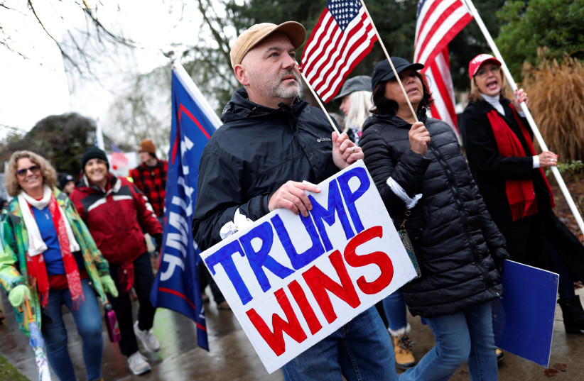 A protester holds a sign saying "Tump wins" at a rally in support of US President Donald Trump at the Oregon State Capitol in Salem, Oregon, US January 6, 2021.  (photo credit: REUTERS/TERRAY SYLVESTER)