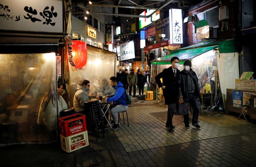People enjoy drinks and dinner at a Japanese izakaya pub, amid the coronavirus disease (COVID-19) outbreak, in Tokyo (credit: REUTERS)