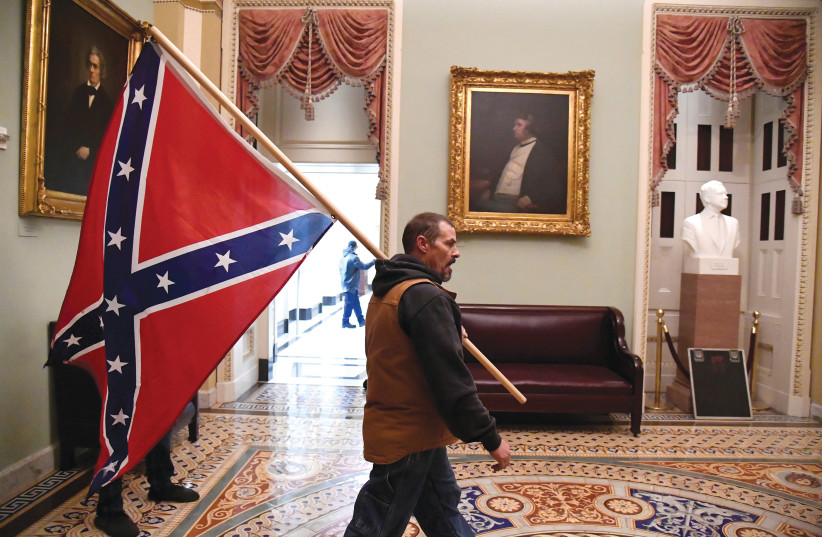 A SUPPORTER of Donald Trump carries a Confederate battle flag through the US Capitol in Washington, DC, on Wednesday. (photo credit: MIKE THEILER/REUTERS)