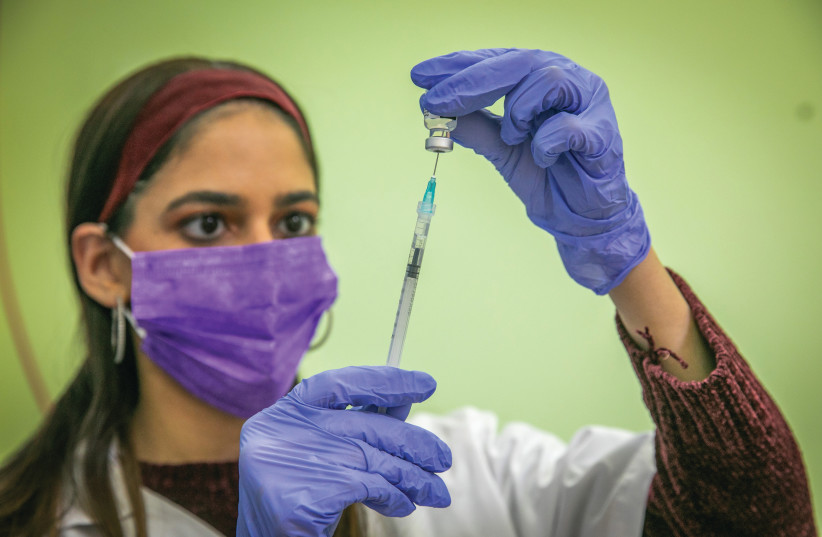 A HEALTHCARE worker prepares a COVID-19 vaccine at a vaccination center in Rehovot on Monday. (photo credit: YOSSI ALONI/FLASH90)