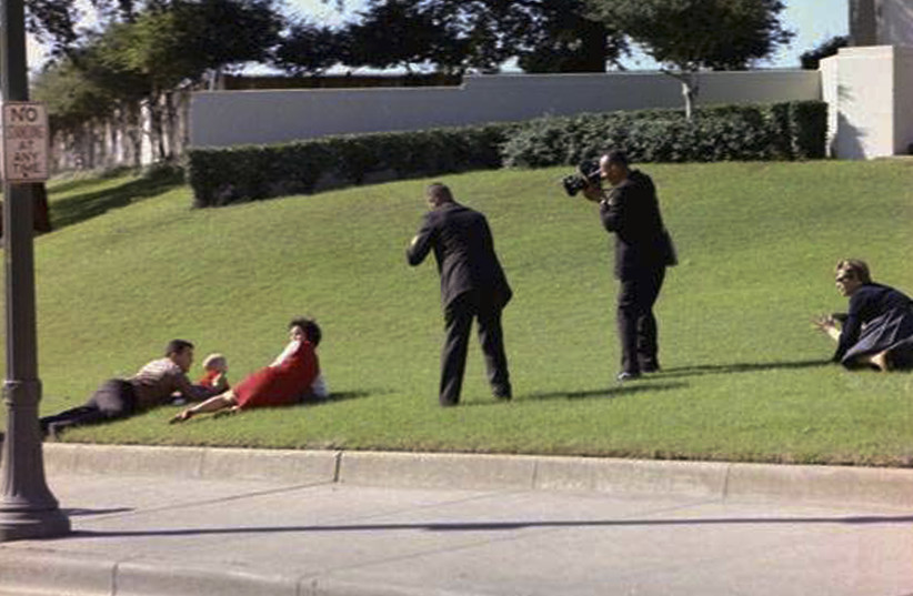 CIVILIAN EYEWITNESSES to the assassination of president John F. Kennedy cover their children in Dealey Plaza after shots were fired, in Dallas on November 22, 1963 (photo credit: REUTERS/CECIL STOUGHTON/THE WHITE HOUSE/JOHN F. KENNEDY PRESIDENTIAL LIBRARY)