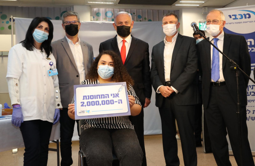 Prime Minister Benjamin Netanyahu and Health Minister Yuli Edelstein meet with the two millionth vaccine recipient.. (photo credit: ODED KARNI/GPO)