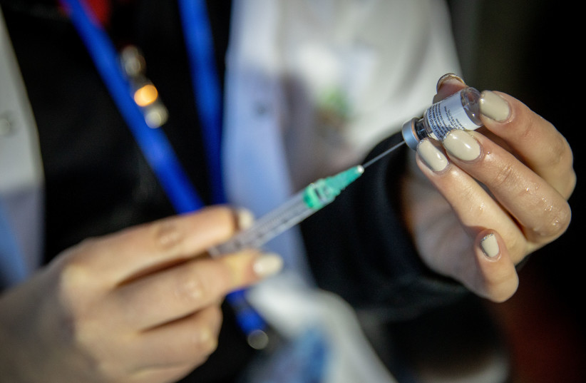 Medical worker prepares a COVID-19 vaccine injection, at a Clalit  vaccination center in Jerusalem, January 21, 2021 (photo credit: YONATAN SINDEL/FLASH 90)