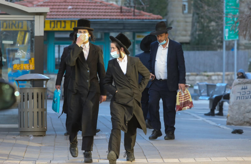 Haredim are seen walking on Strauss Street near Mea She'arim in Jerusalem following riots against COVID-19 regulations, on January 25, 2021. (photo credit: MARC ISRAEL SELLEM/THE JERUSALEM POST)