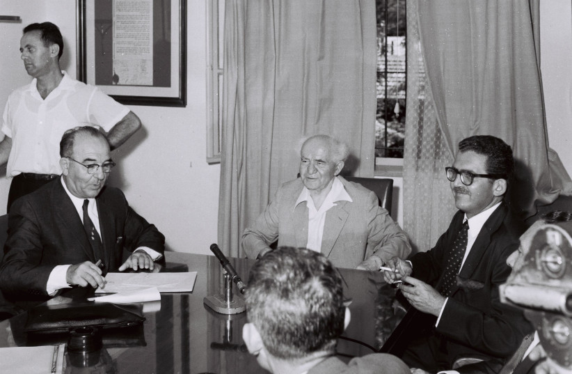 Baron Edmond de Rothschild (right) and Levi Eshkol, Israel’s finance minister, sign a 49- year contract for an Eilat-Haifa pipeline, witnessed by prime minister David Ben-Gurion on July 17, 1959. (photo credit: ARON MIRLIN/GPO)