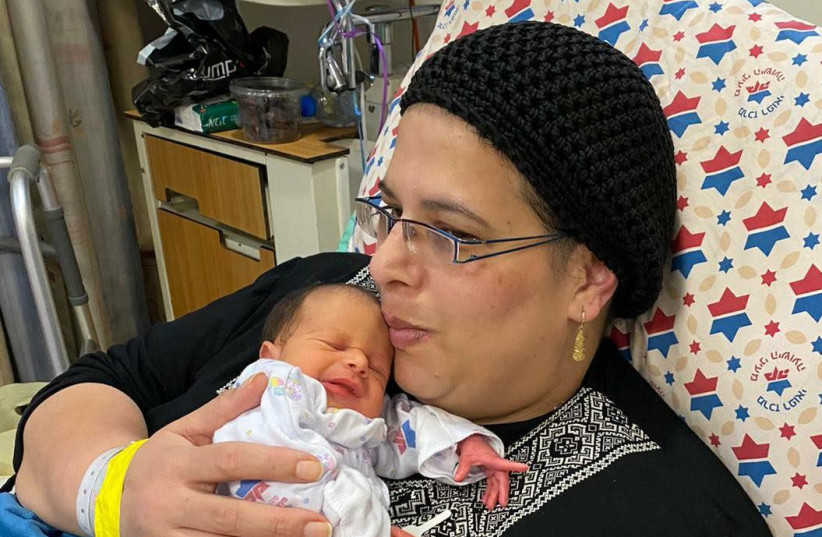 Noa Oz, with her baby, after being sedated and ventilated for seven weeks due to coronavirus complications, January 29, 2021.  (photo credit: HADASSAH SPOKESPERSON)