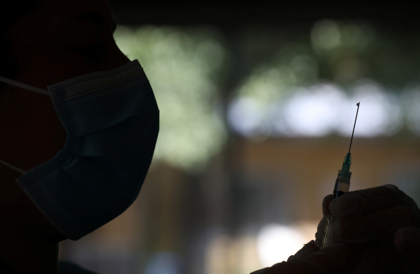 A healthcare worker prepares to administer a dose of Sinovac's CoronaVac coronavirus disease (COVID-19) vaccine as Chile starts to vaccinate elderly people living in nursing homes in Santiago, Chile, February 4, 2021.  (photo credit: REUTERS/IVAN ALVARADO)