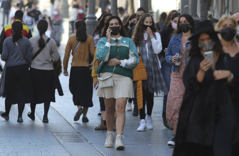 A woman with a COVID-19 mask walks in Jerusalem on Sunday February 14 2021  (photo credit: MARC ISRAEL SELLEM)