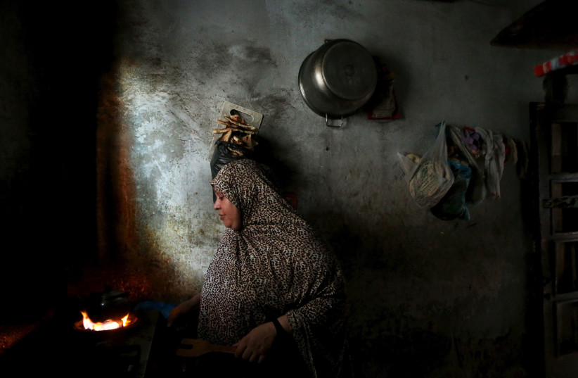 A Palestinian woman makes tea inside her house during power cut at Shatti (beach) refugee camp in Gaza City July 23, 2015. Palestinian Energy officials said residents of Gaza (photo credit: REUTERS)