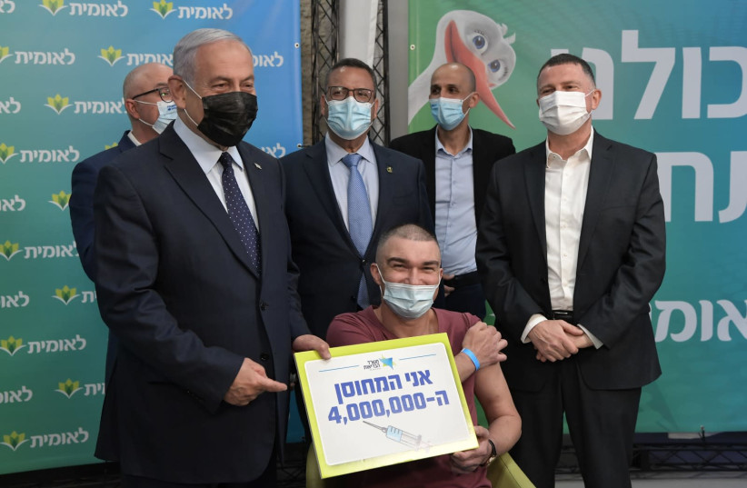 Prime Minister Benjamin Netanyahu and Health Minister Yuli Edelstein with the 4 millionth vaccine receiver (photo credit: KOBI GIDEON/GPO)