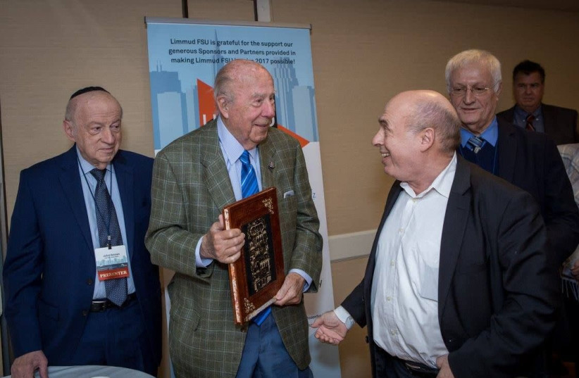 George Shultz, with book, at a 2017 Limmud FSU conference with, from left to right, Julius Berman, Natan Sharansky and Chaim Chesler.  (photo credit: EKATERINA EFIMOVA)