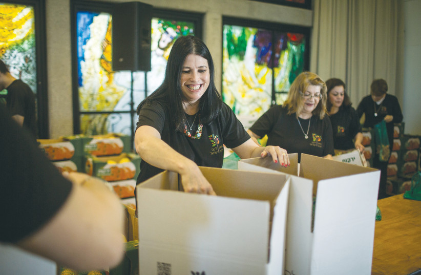 VOLUNTEERS PACK boxes with food for families in need ahead of Passover, at the President’s Residence in 2016. (photo credit: HADAS PARUSH)