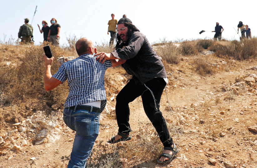 A Palestinian man scuffles with an Israeli during a protest against settlements, Asira al-Qibliya, West Bank (photo credit: MOHAMAD TOROKMAN/REUTERS)