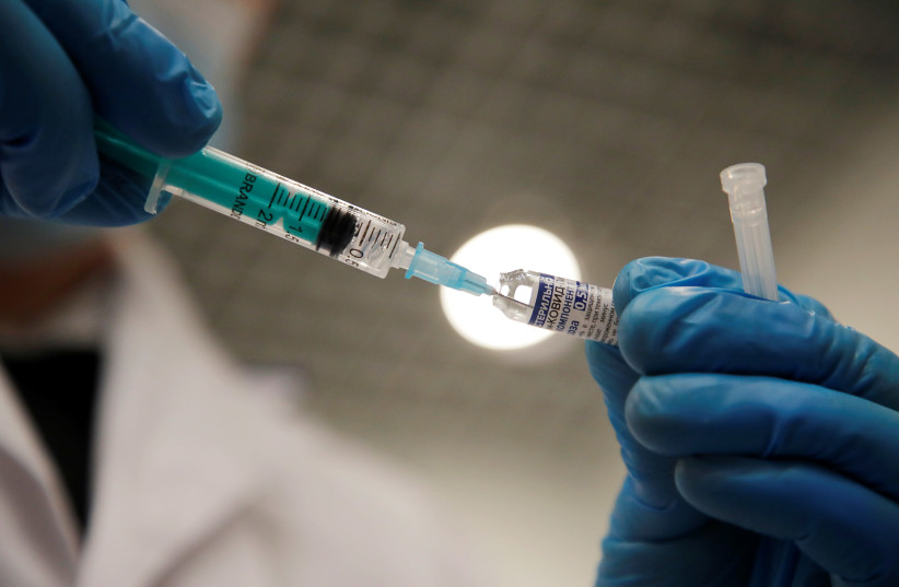 A medical worker holds a syringe with Sputnik V (Gam-COVID-Vac) vaccine against the coronavirus disease (COVID-19) before administering an injection at a vaccination centre in a shopping mall in Saint Petersburg, Russia February 24, 2021. (credit: REUTERS)