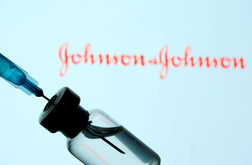 A vial and sryinge are seen in front of a displayed Johnson&Johnson logo in this illustration taken January 11, 2021.  (photo credit: REUTERS/DADO RUVIC/ILLUSTRATION/FILE PHOTO)