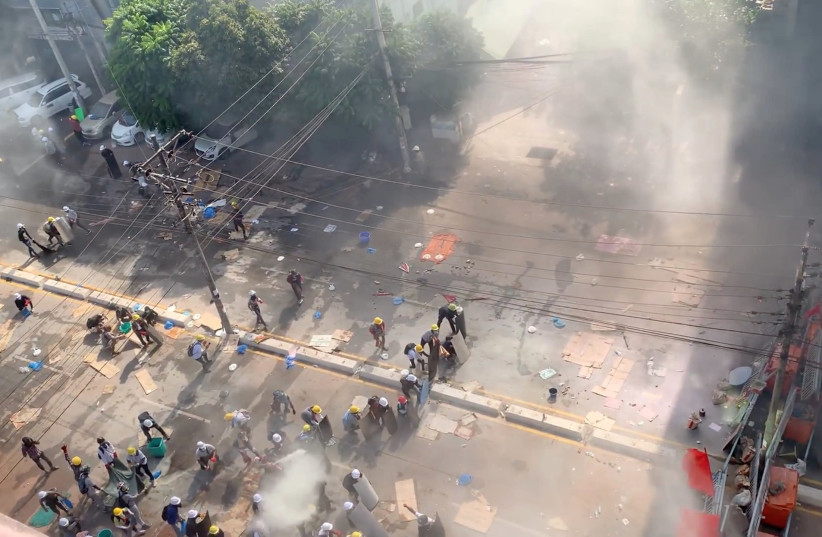 Demonstrators are seen behind makeshift barricades during a protest in Yangon, Myanmar, March 4, 2021, in this still image taken from a video.  (photo credit: REUTERS)
