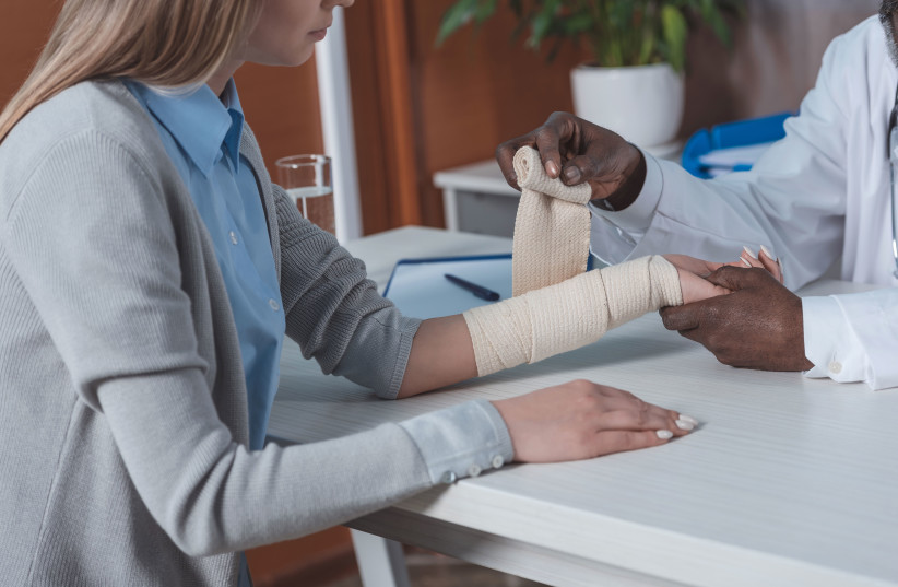 Illustrative image of a doctor bandaging patient hand.  (photo credit: IGOR VETUSHKO)