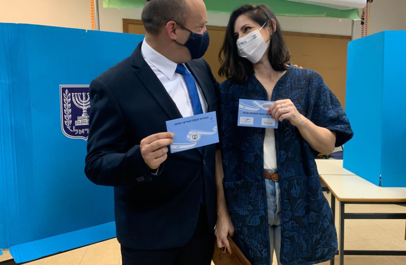 Yamina chairman Naftali Bennett and his wife Gilat voted in Ra'anana on March 23, 2021.  (photo credit: ARIEL ZANDBERG)