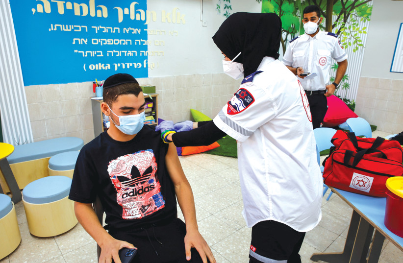 A STUDENT receives a COVID-19 vaccination at Amal High School in Beersheba last week. (photo credit: FLASH90)