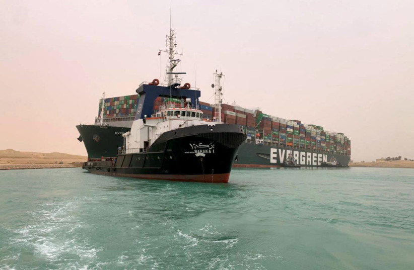A handout picture released by the Suez Canal Authority on March 24, 2021 shows a part of the Taiwan-owned MV Ever Given (Evergreen), a 400-meter-long and 59-meter wide vessel, lodged sideways and impeding all traffic across the waterway of Egypt's Suez Canal. (photo credit: SUEZ CANAL AUTHORITY/HANDOUT/AFP VIA GETTY IMAGES))