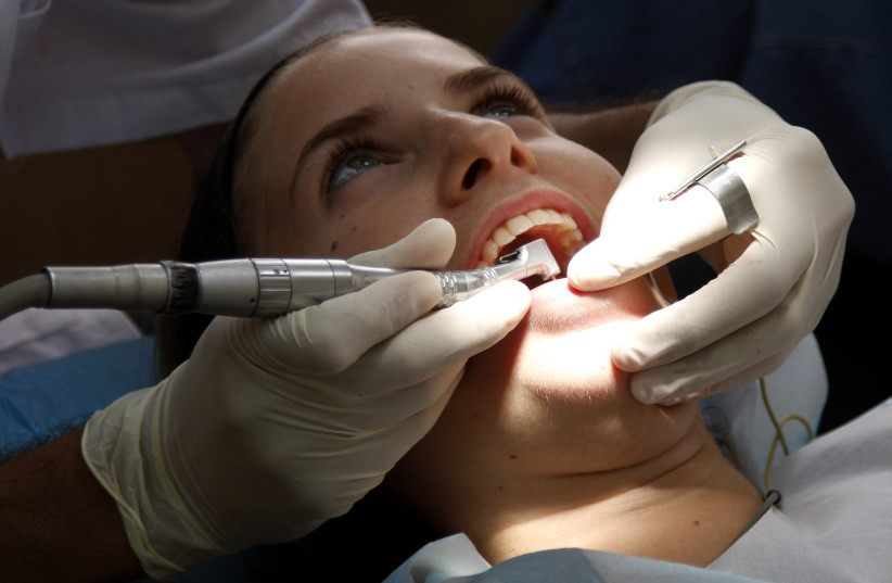 A young lady has dental work done at a local dentist in Jerusalem July 22, 2008.  (credit: DANIEL DREIFUSS/FLASH 90)