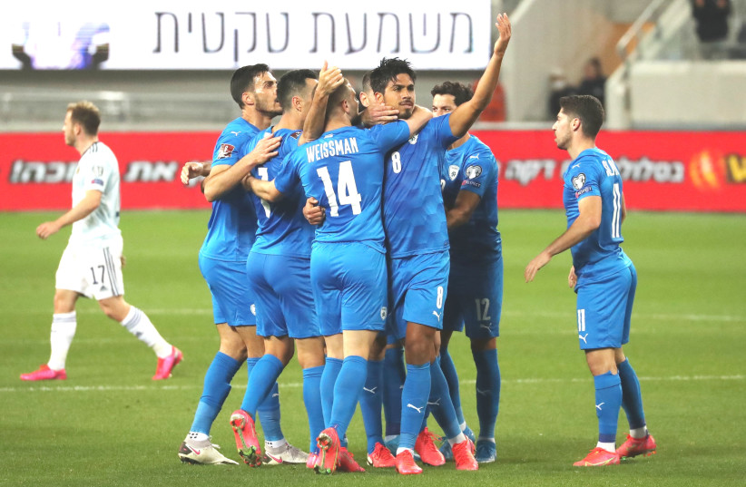 ISRAEL MIDFIELDER Dor Peretz (8) celebrates on the pitch with his teammates after scoring a 44th-minute tally on Sunday night in the blue-and-white’s 1-1 draw with visiting Scotland in World Cup qualifying action at Bloomfield Stadium.  (photo credit: AMMAR AWAD/REUTERS)