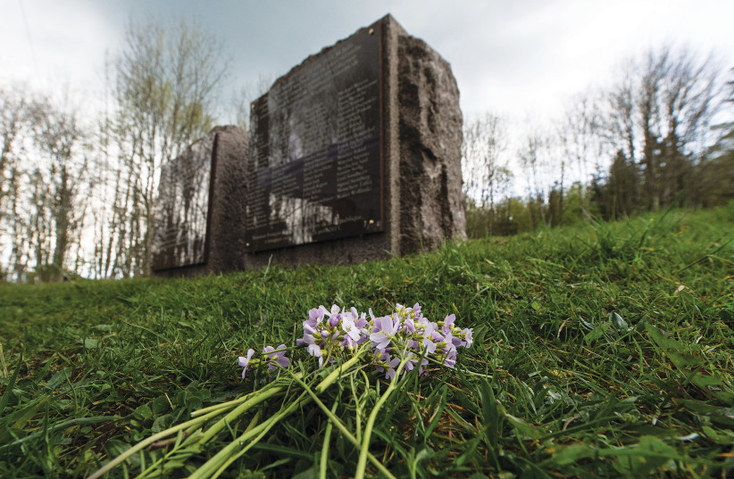 LES FLEURS SONT placées près des monuments commémoratifs où se trouvait autrefois la chambre à gaz, au camp de concentration de Natzweiler-Struthof à Natzweiler, en France, en 2015 (crédit photo: PATRICK SEEGER / REUTERS)