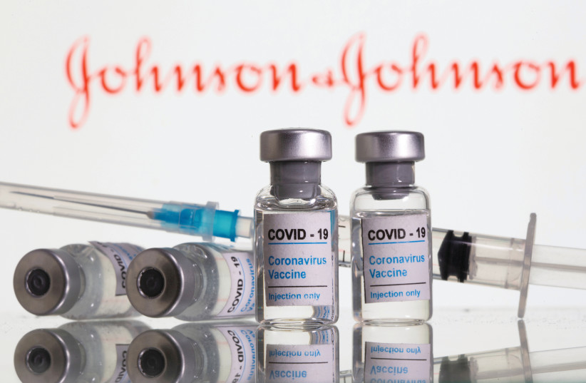 VIALS LABELED ‘COVID-19 Coronavirus Vaccine’ and a syringe are seen in front of displayed Johnson&Johnson logo. (credit: DADO RUVIC/REUTERS)