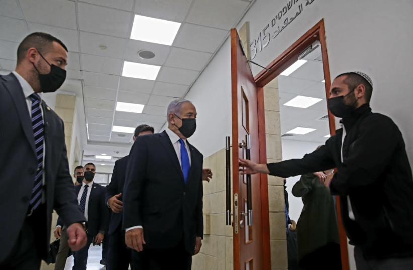 Prime Minister Benjamin Netanyahu is seen entering the courtroom at the Jerusalem District Court for his hearing. (photo credit: OREN BEN HAKOON/POOL)