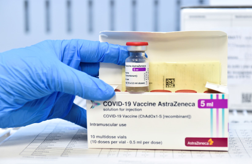 A healthcare worker shows a vial and a box of the AstraZeneca coronavirus disease (COVID-19) vaccine, as vaccinations resume after a brief pause in their use over concern for possible connection to blood clots, in Turin, Italy, March 19, 2021. (photo credit: REUTERS/MASSIMO PINCA/FILE PHOTO)