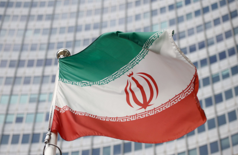 The Iranian flag waves in front of the International Atomic Energy Agency (IAEA) headquarters, before the beginning of a board of governors meeting, amid the coronavirus disease (COVID-19) outbreak in Vienna, Austria, March 1, 2021. (photo credit: REUTERS/LISI NIESNER/FILE PHOTO)