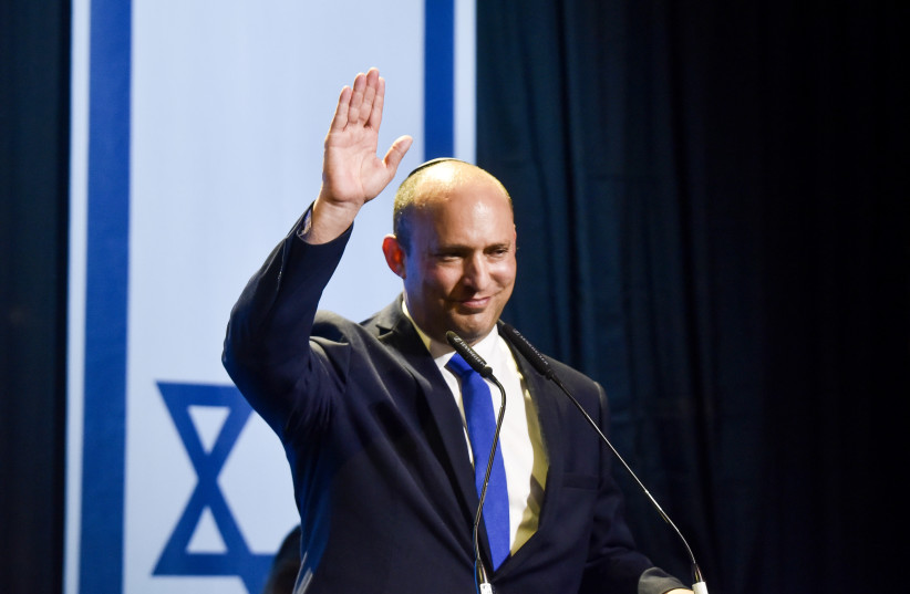 Naftali Bennett, head of Yamina party and party members seen with Yamina supporters at the party headquarters in Petah Tikva, on elections night, on March 23, 2021.  (photo credit: AVI DISHI/FLASH90)