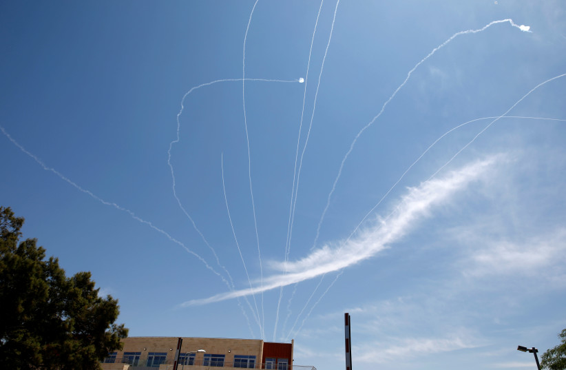TRAILS ARE seen in the sky as an Iron Dome projectile intercepts a rocket fired from Gaza, above Ashkelon in May 2019.  (photo credit: AMIR COHEN/REUTERS)